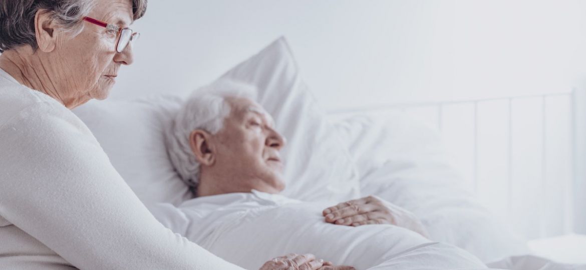 Elderly woman supporting sick husband